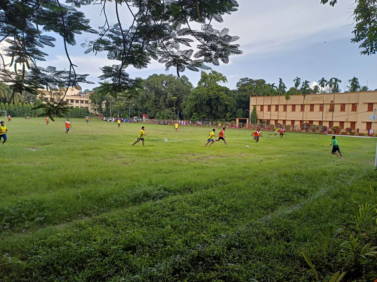 Students playing football on a school ground in Belur Math, Howrah, West Bengal, with a ball on the pitch