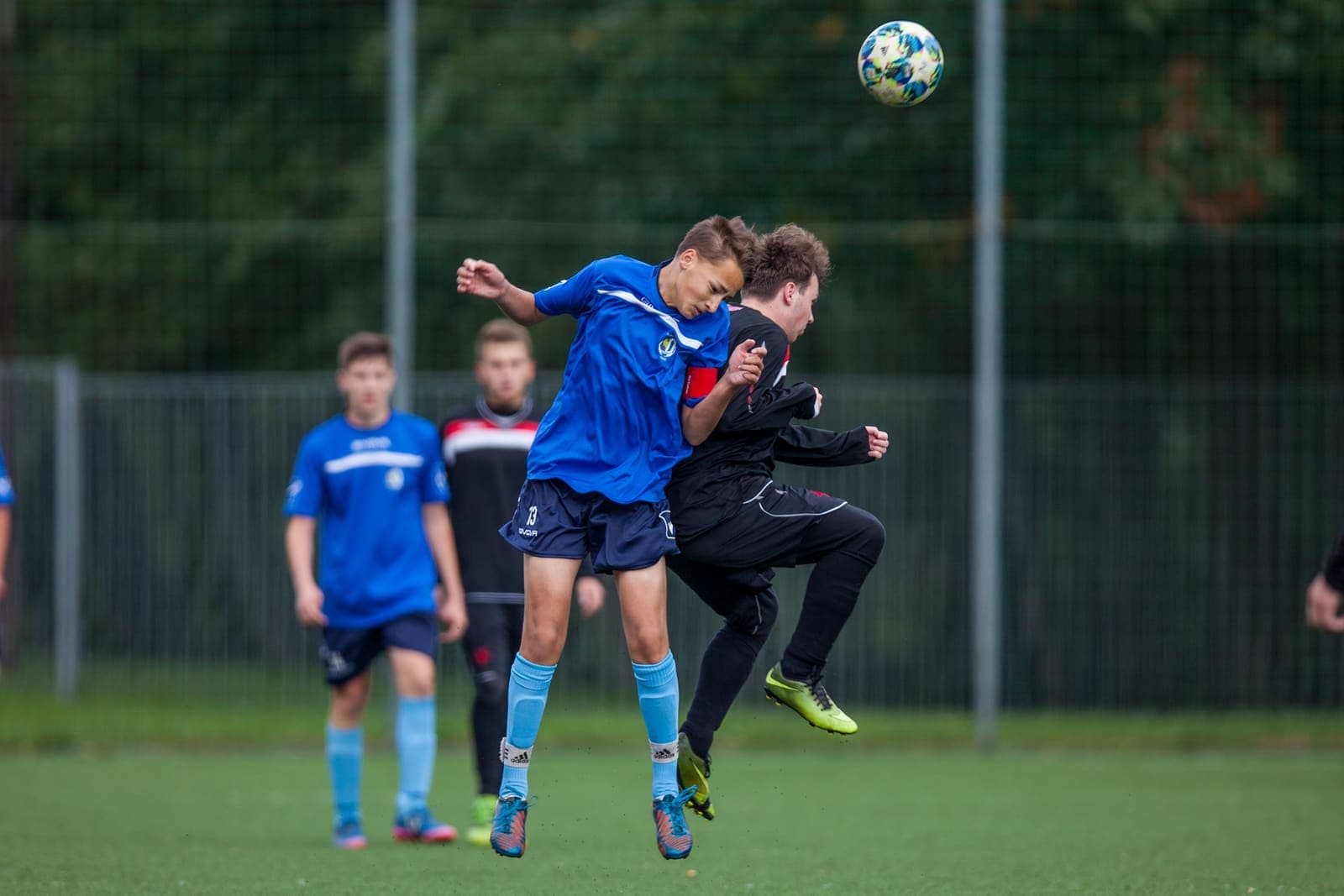 Youth footballers jumping to contest a high ball