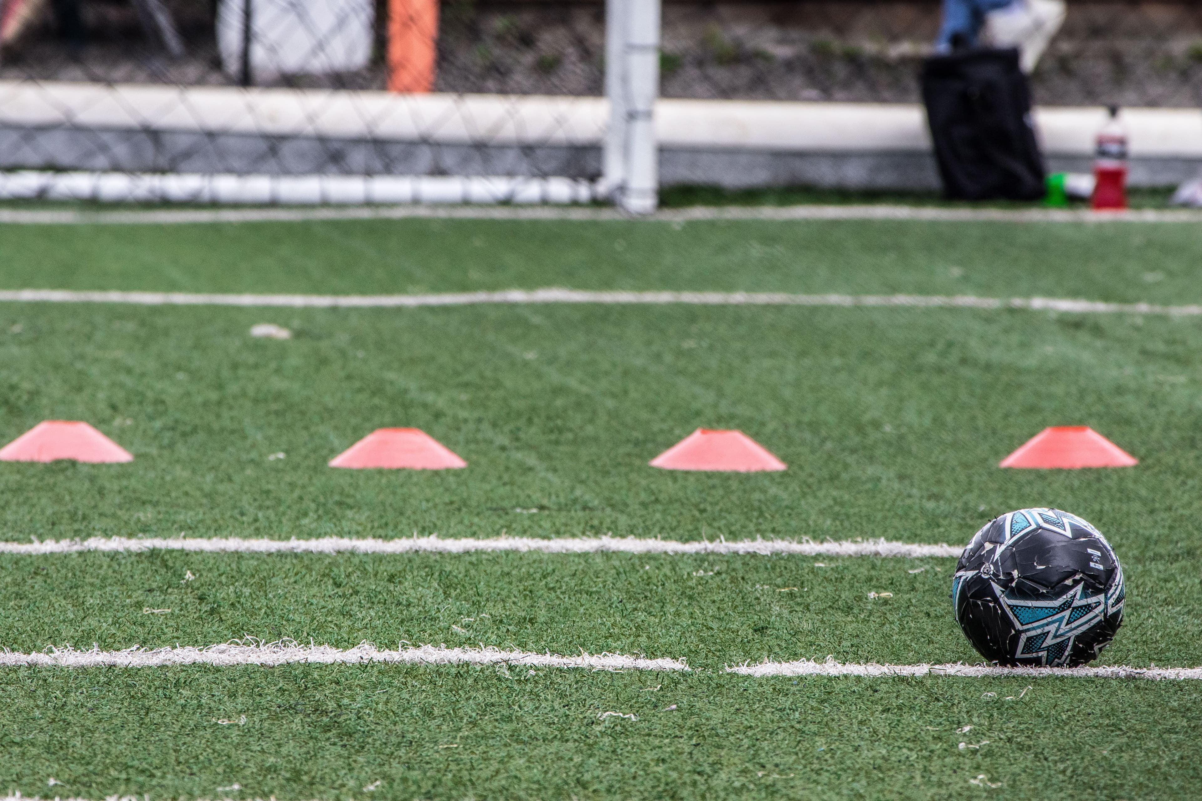 Training cones and football on marked turf