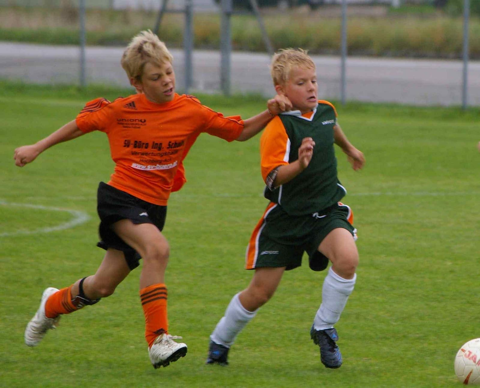 Two young footballers chasing the ball during a youth match