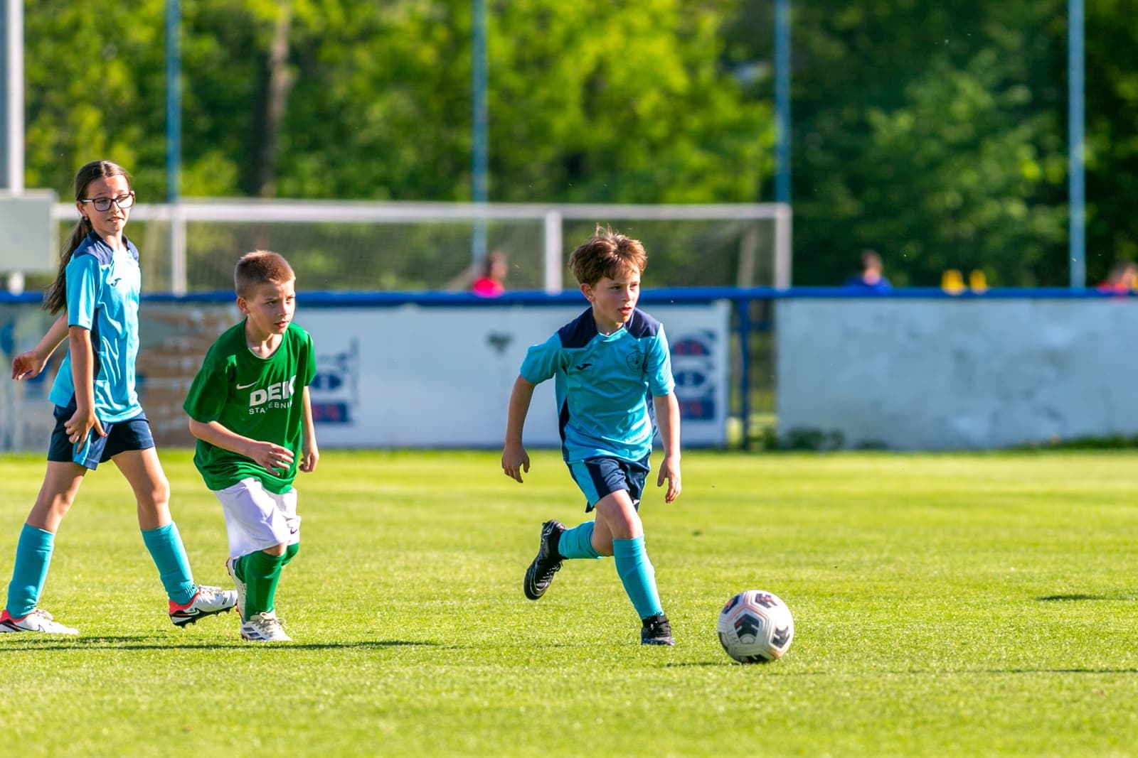 Young footballer running onto a ball during a youth match
