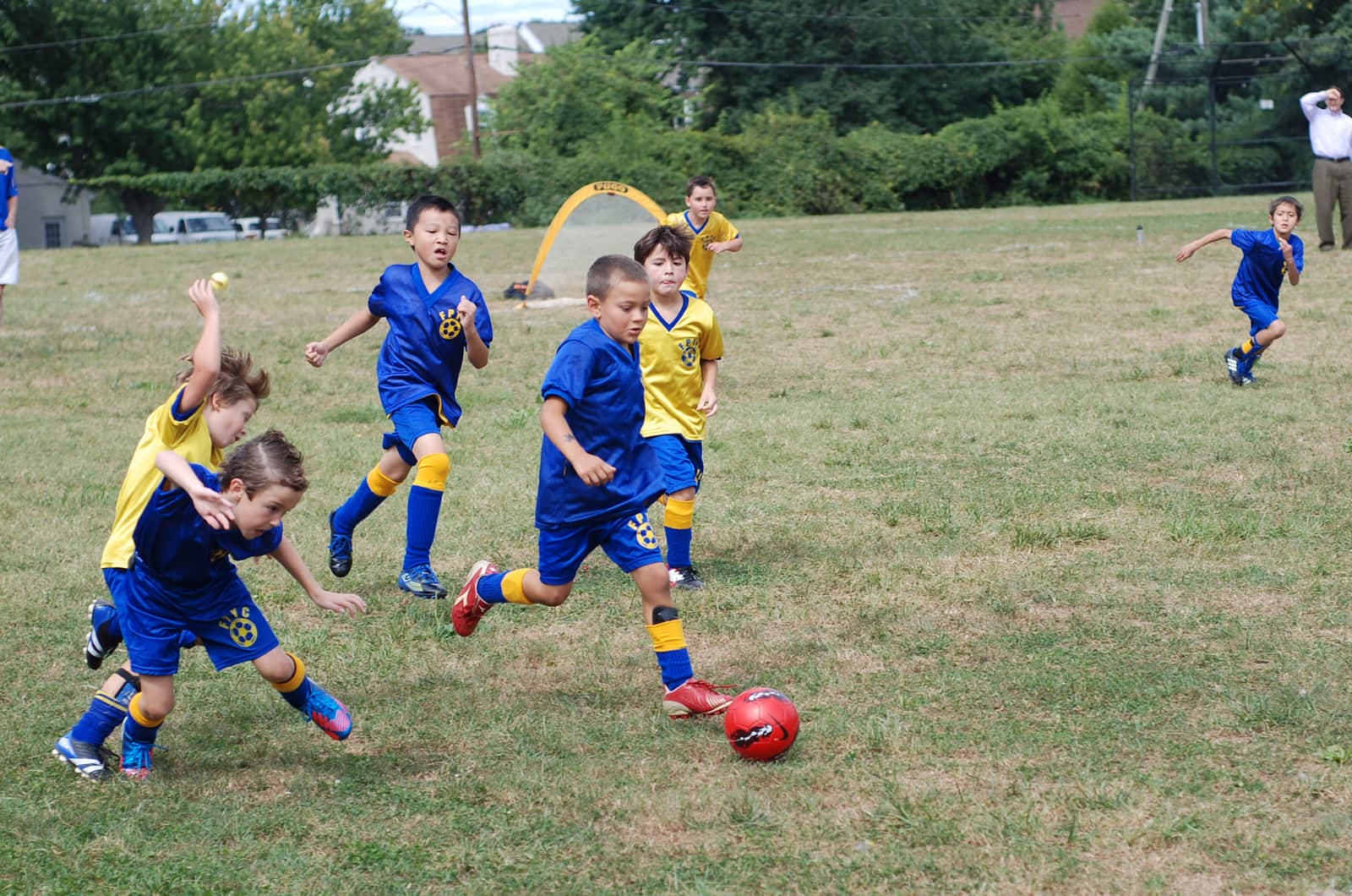 Youth soccer training with children dribbling on a grass field