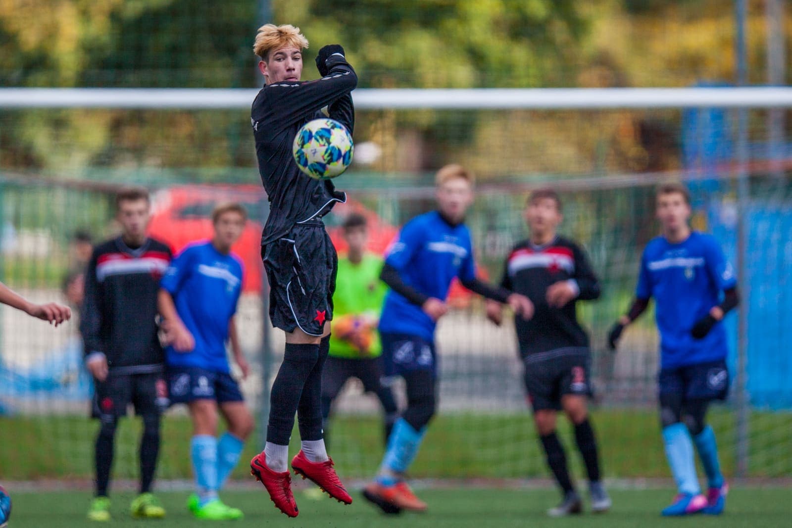 Youth footballer jumping to throw the ball back into play