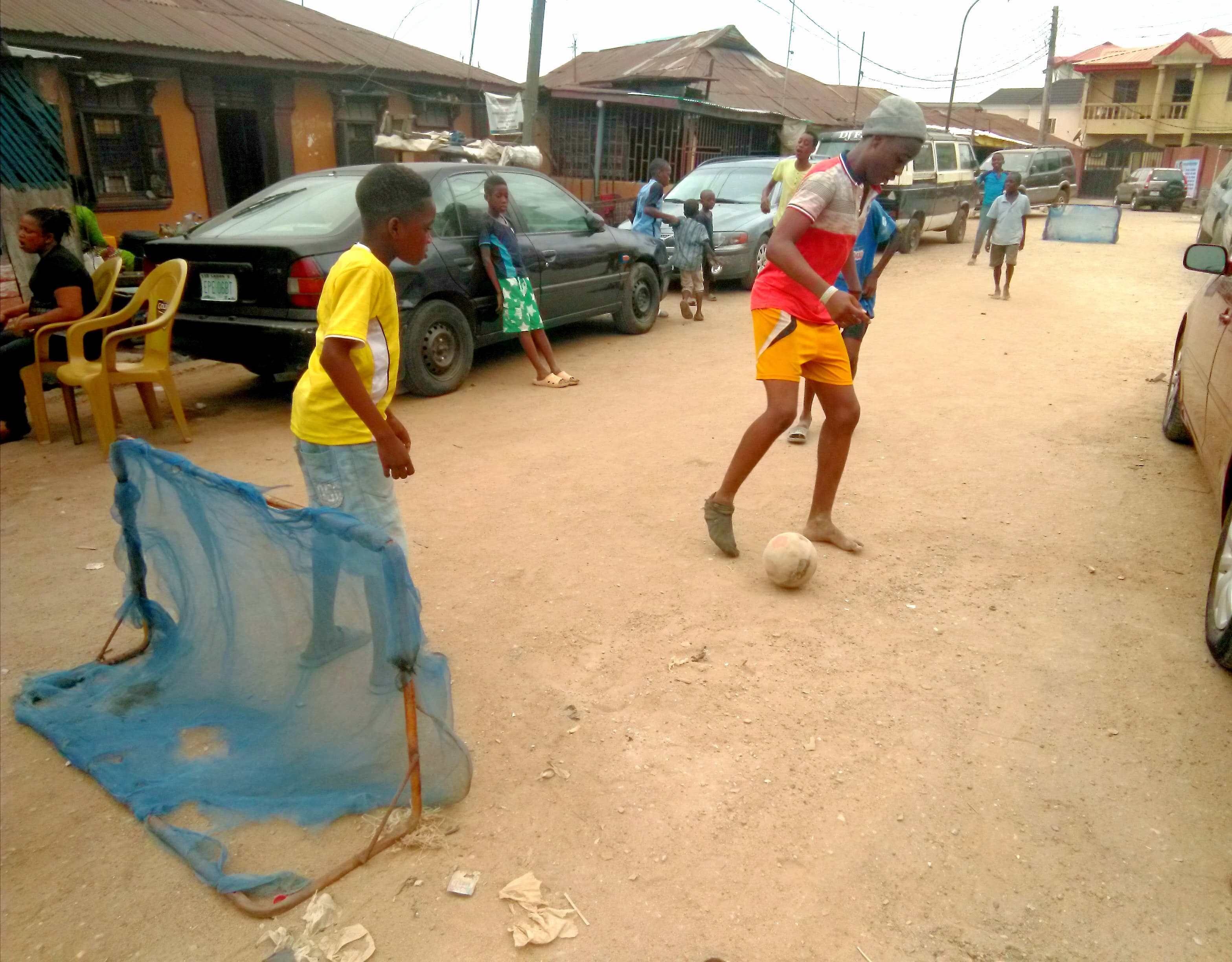 Children playing football with a ball on court