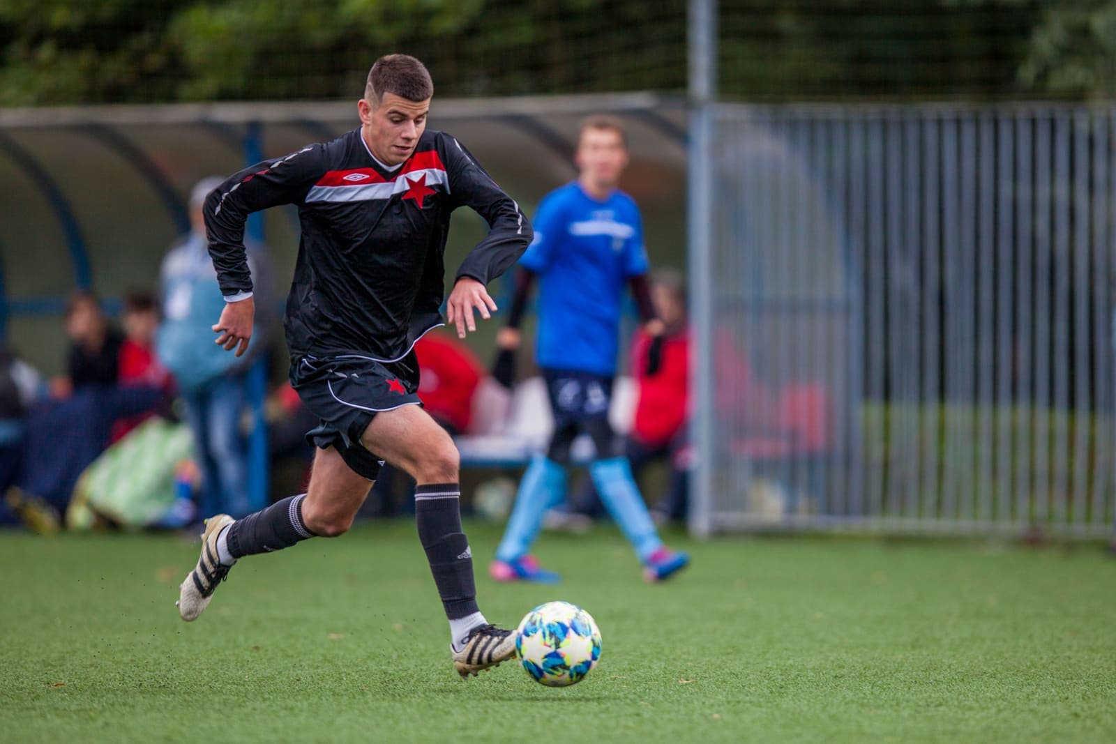 Youth footballer dribbling a ball at pace