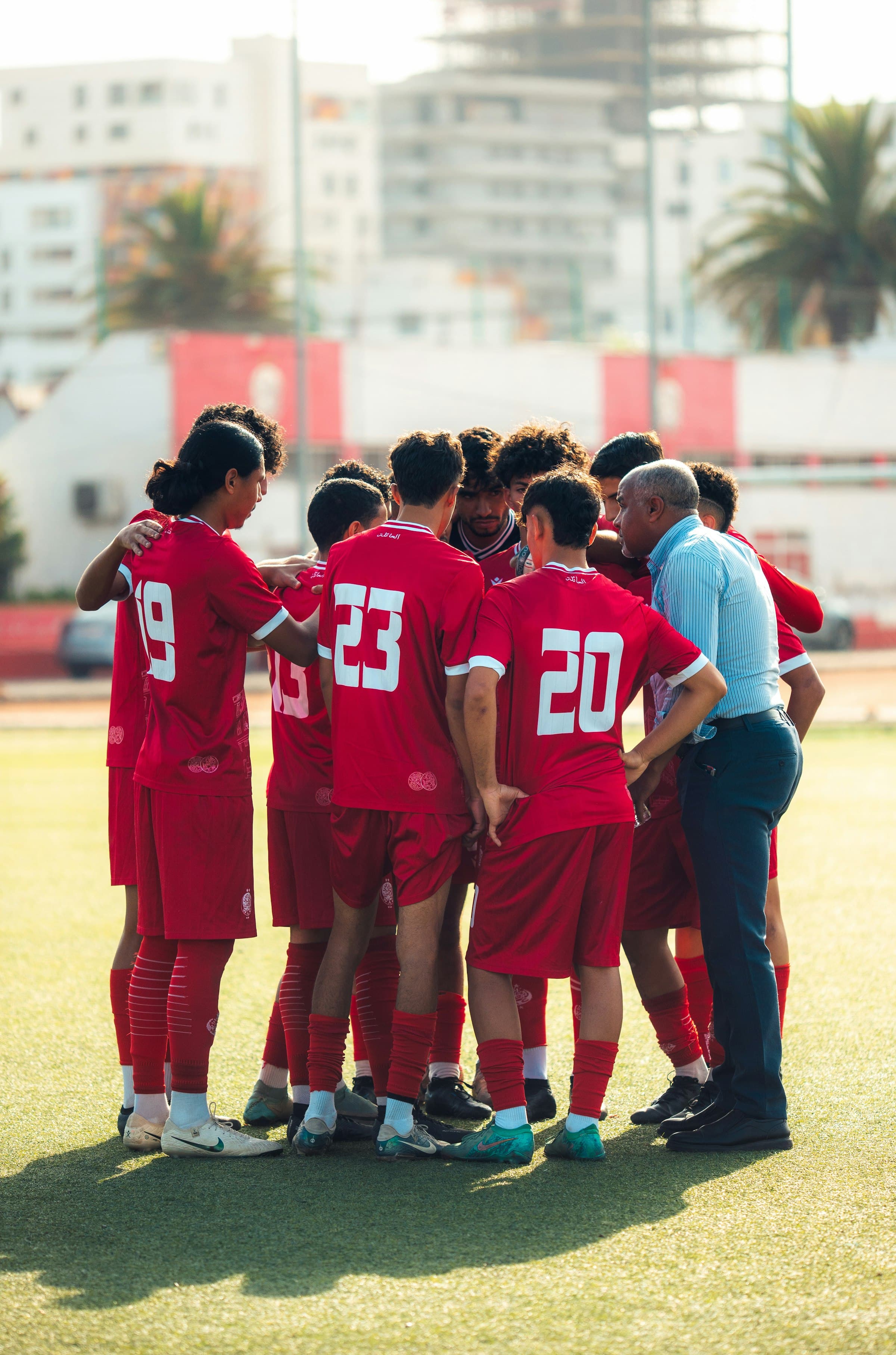 Women's soccer team huddle on field