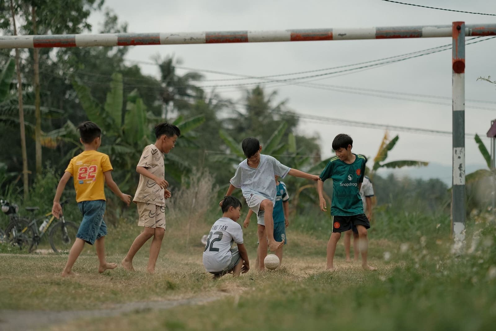 Children playing football on green field in India