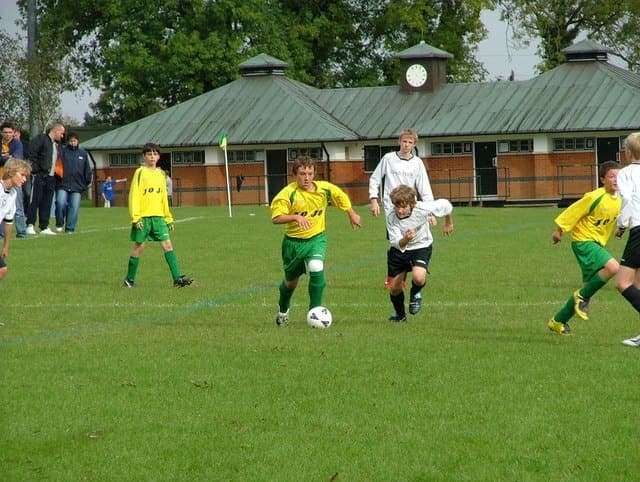 Youth football match in England with ball in play