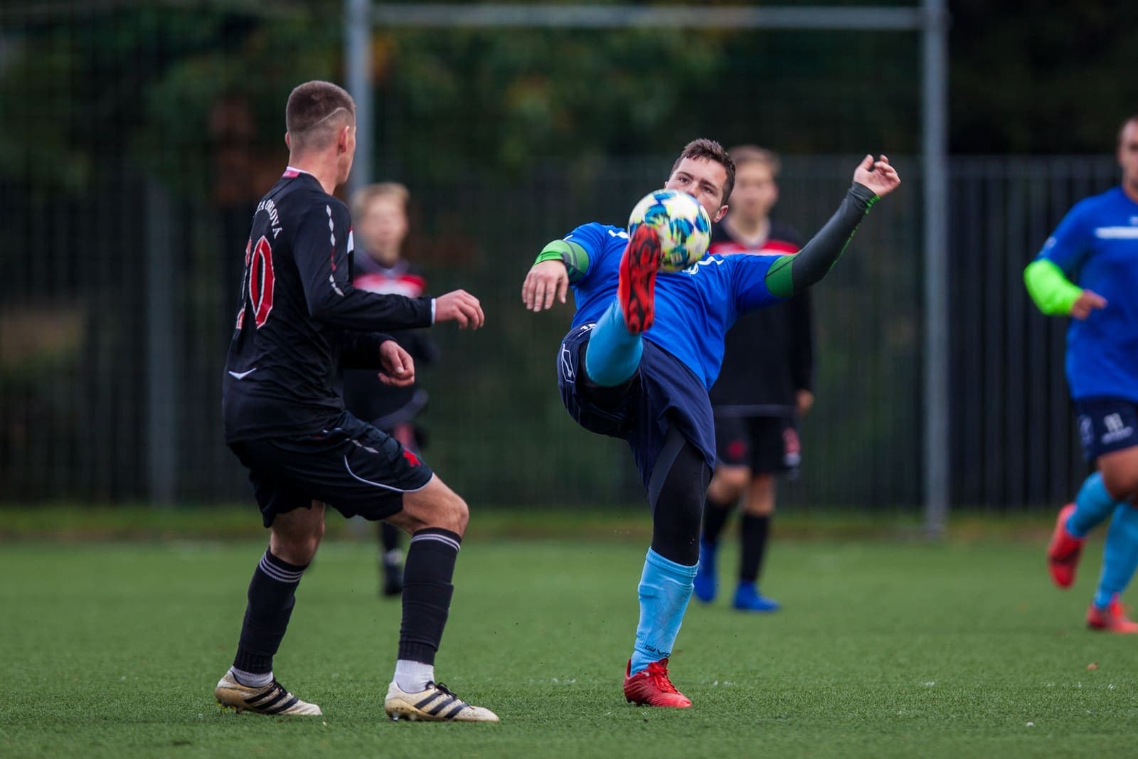 Footballer striking a high ball during a match