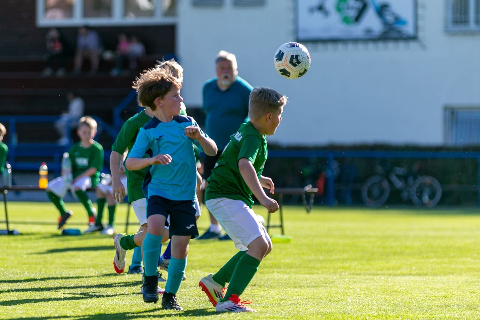 Youth footballers contesting a high ball during a match