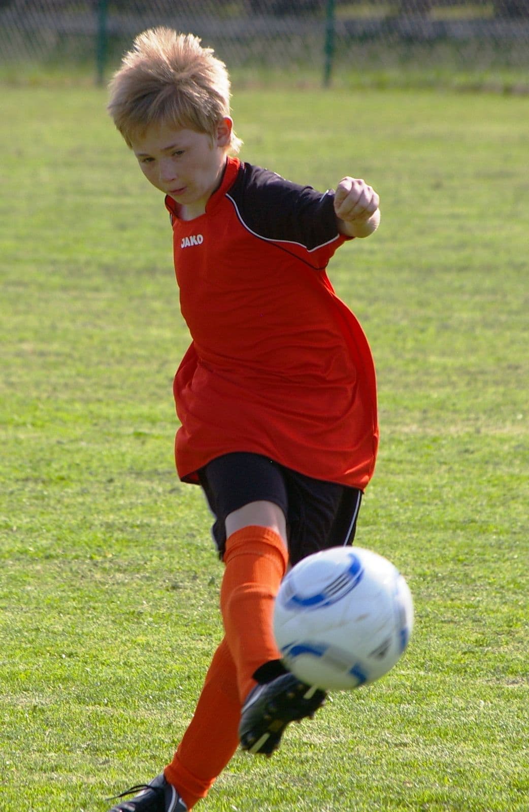 Youth footballer shooting with ball in frame