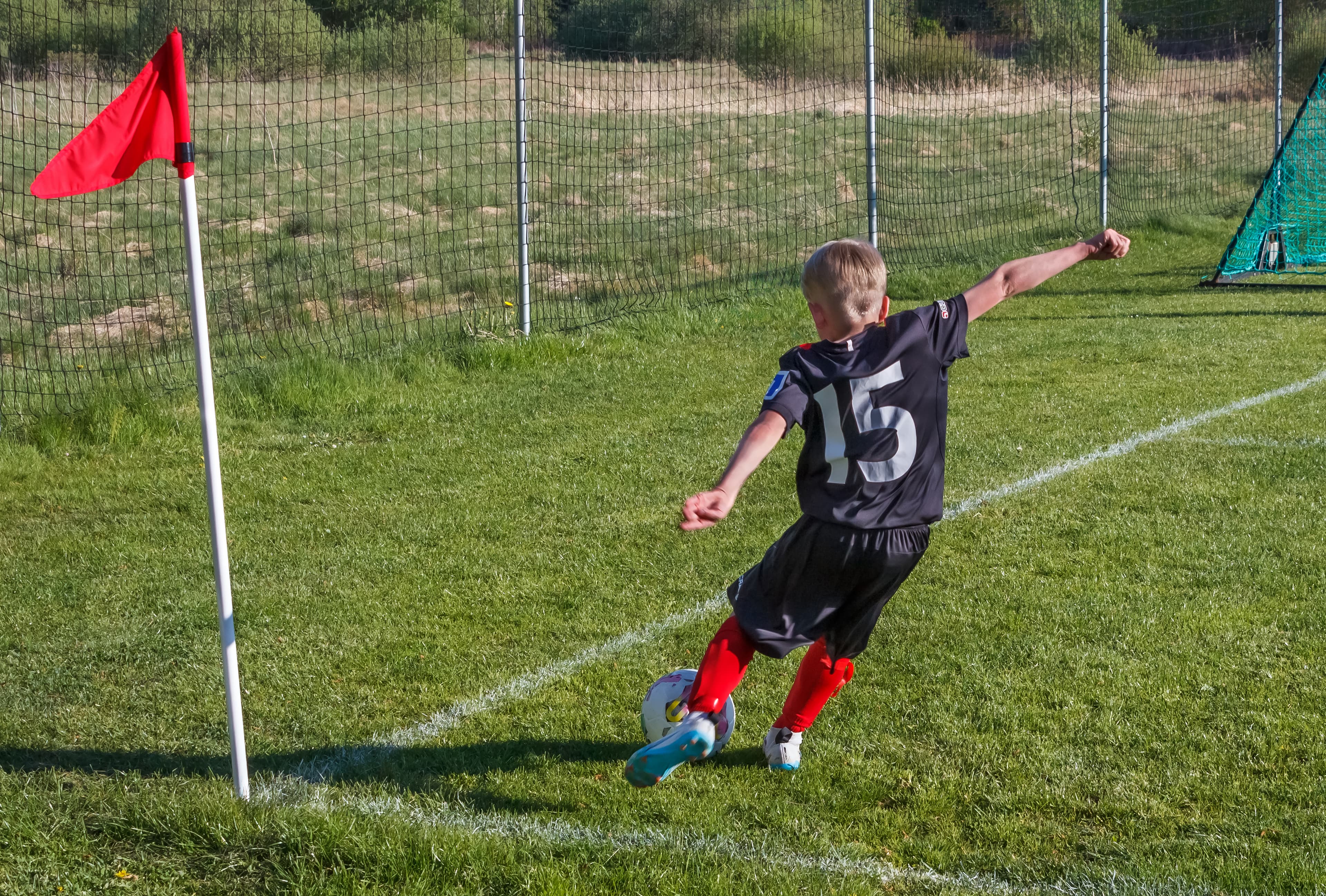 Youth football corner kick — ball in play
