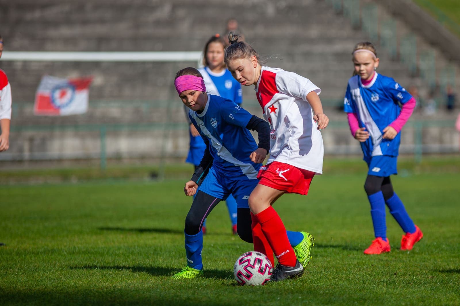 Two girls contesting a dribble during a youth football match