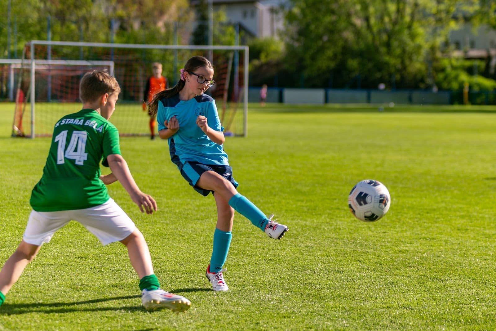 Young players contesting a football in mid-air