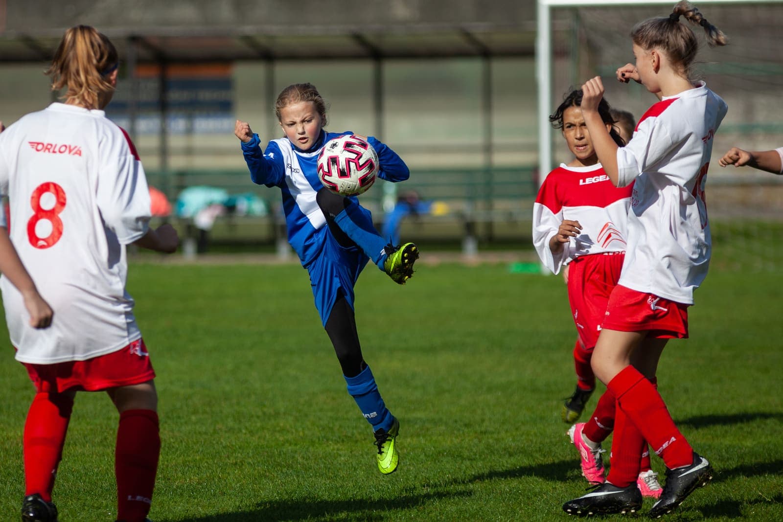 Youth footballer volleying the ball during a girls match